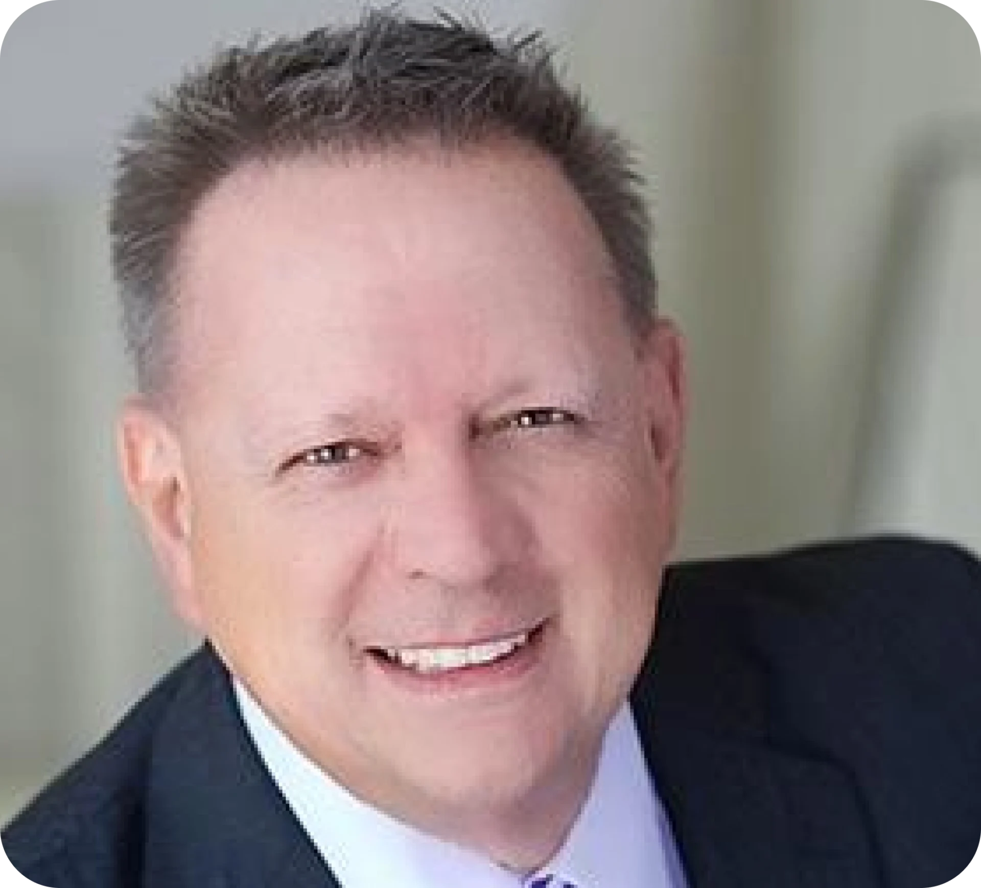 Smiling man in a suit and tie.