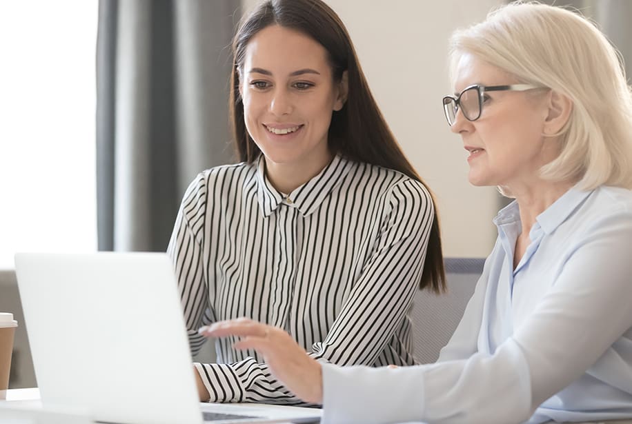 Two women working together on a laptop.